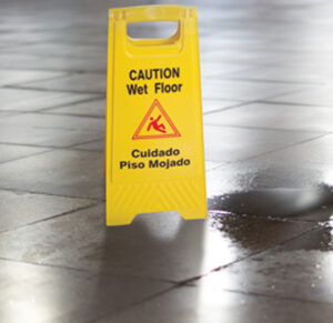 Wet entry matting and caution sign at a San Diego office building entrance